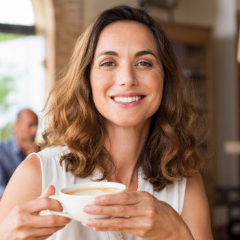 Mature woman smiling holding cup Dunwoody Dental Health care