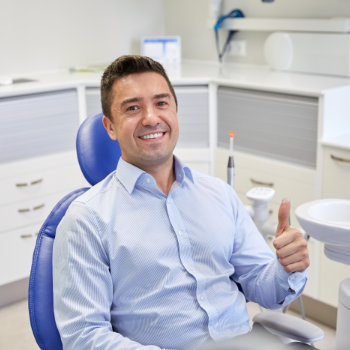 Satisfied man thumbs up in dentist chair Dunwoody Dental Health